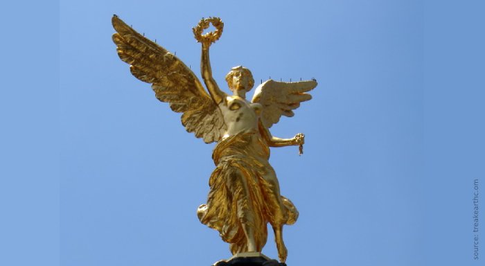 Nike tiene nella mano destra una corona di alloro, simbolo di gloria e vittoria; nella mano sinistra una catena spezzata, simbolo di libertà e indipen